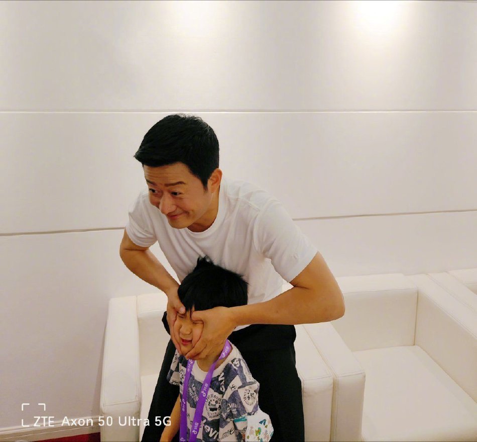 组图：吴京晒与小儿子工作花絮照 揪头发捏脸搞怪十足